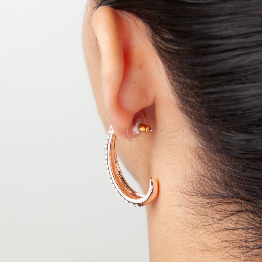 Back view of an ear showing how a goldtone disc earring back looks when attached to an earring behind an earlobe.
