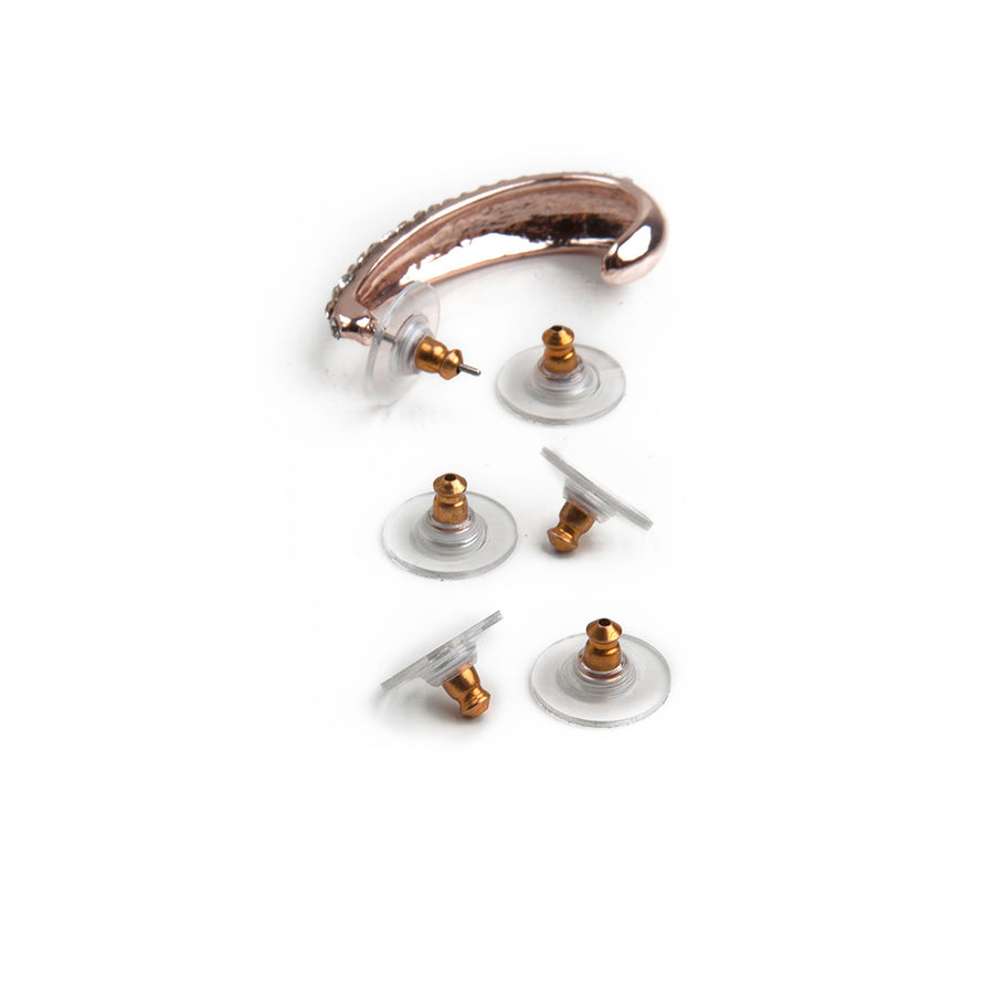 Goldtone disc earring backs laid out next to a gold u-shaped earring showing how the disc earring backs fit onto stud earrings.