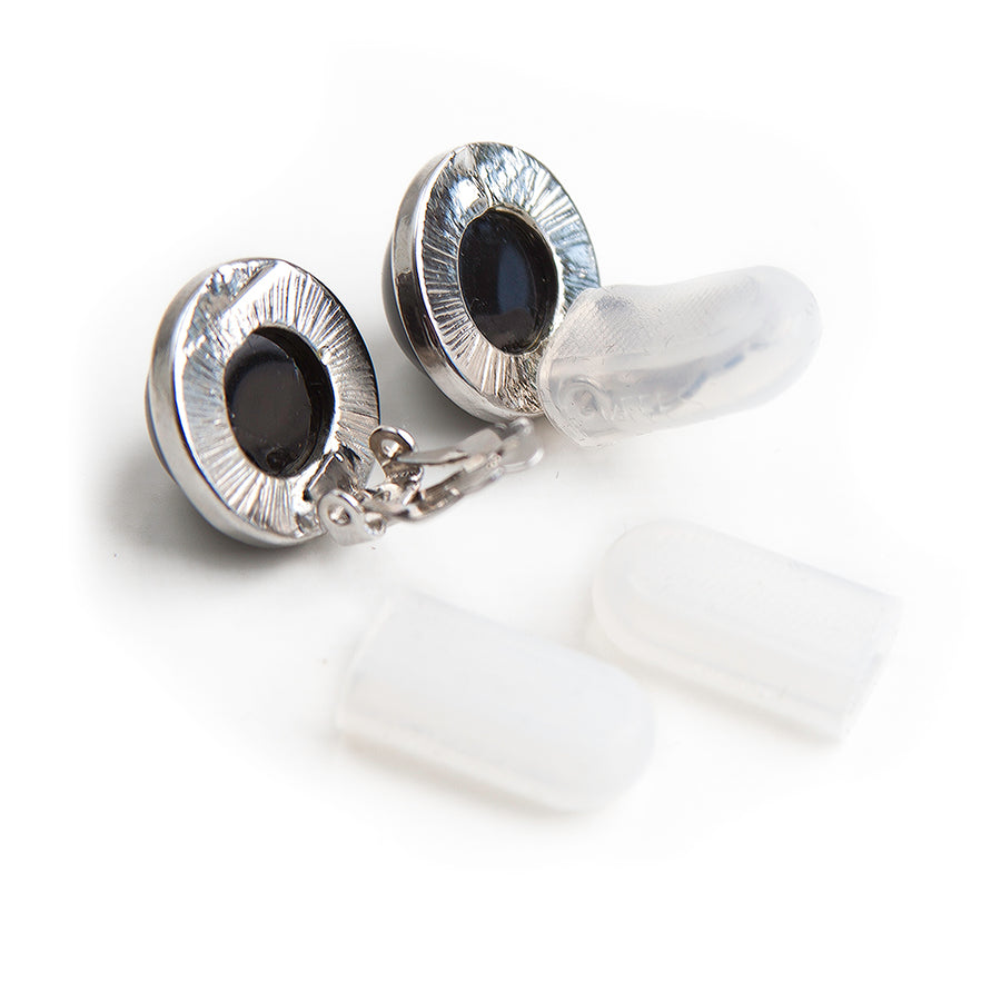 Clear clip earring cushions next to and on a pair of clip earrings to show how they fit properly.