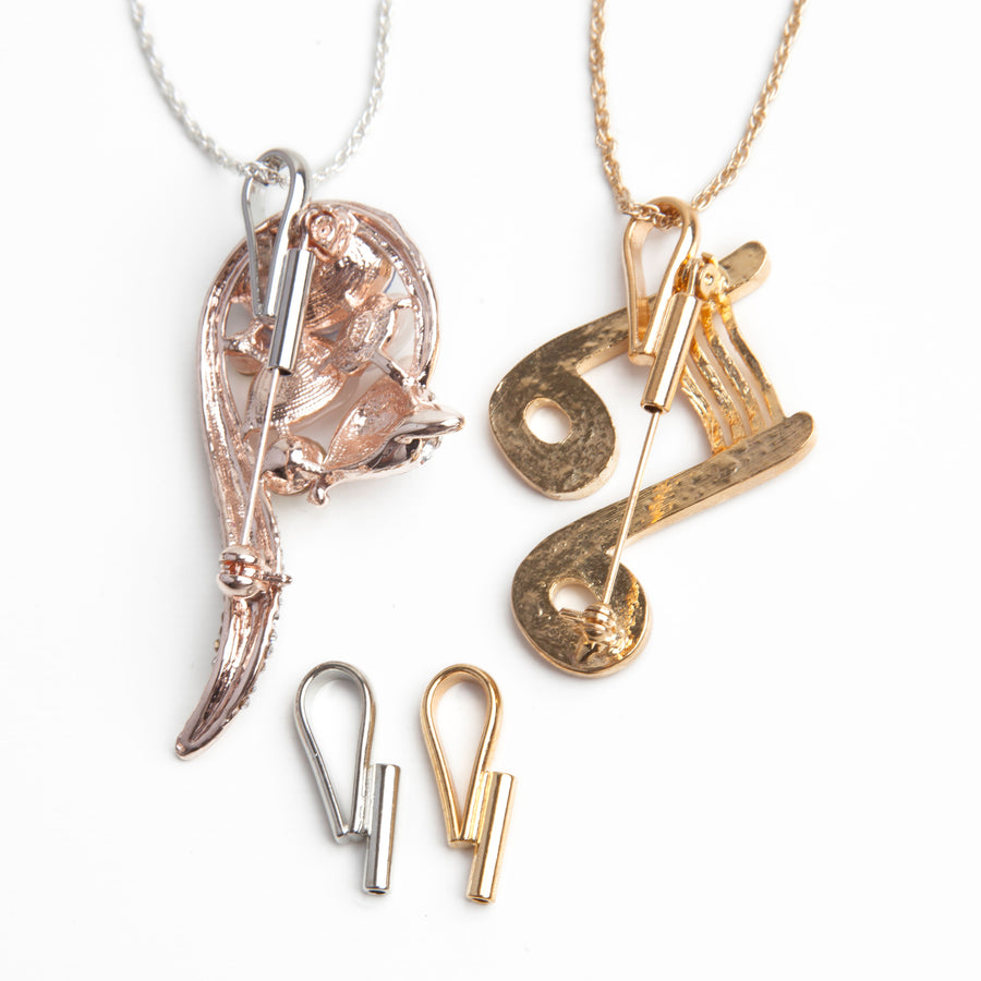 Two vertical pin to pendant converters in gold and silver laid next to to two necklaces in gold and silver using vertical pin to pendant converters with vertical brooches.