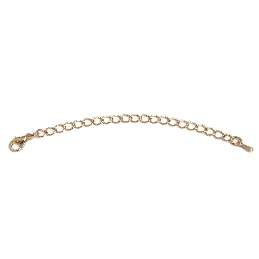 one gold necklace extender laid out on a white background.