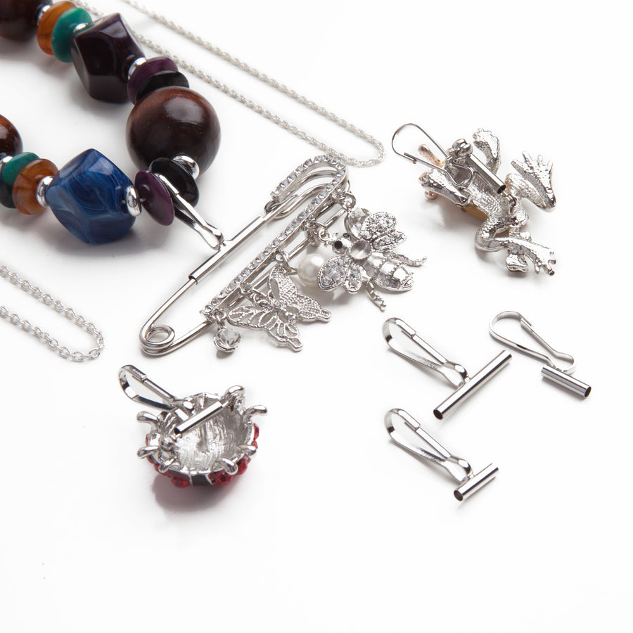 a small horizontal pin to pendant converter, a large horizontal pin converter, and a small vertical pin converter laid out below two silver necklaces and a large beaded necklace using pin converters with brooches.