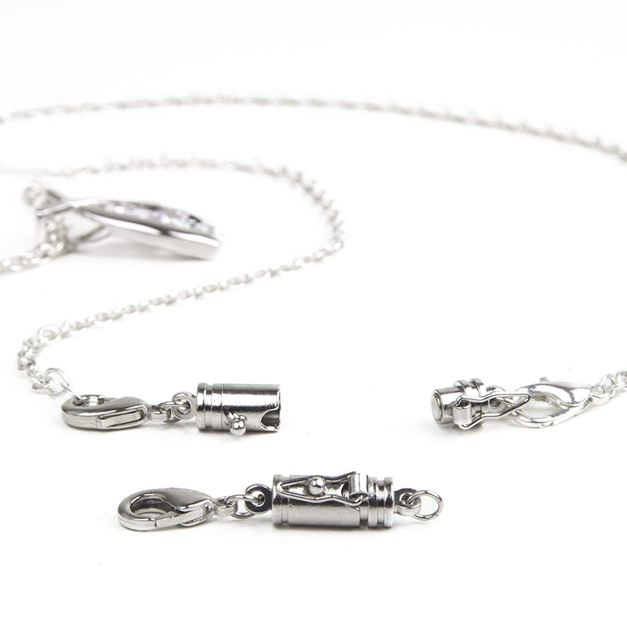 small silver magnetic clasp with a safety catch on one side in front of a silver necklace with attached small silver magnetic clasp with a safety catch on the side.