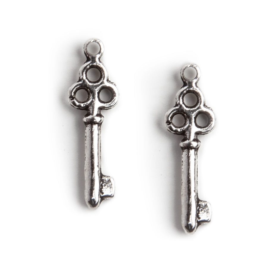 stainless steel key charm with four openings against a white background