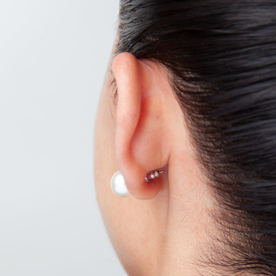 back view of an ear showing where a small aluminum earring backs sits when attached to a stud earring.