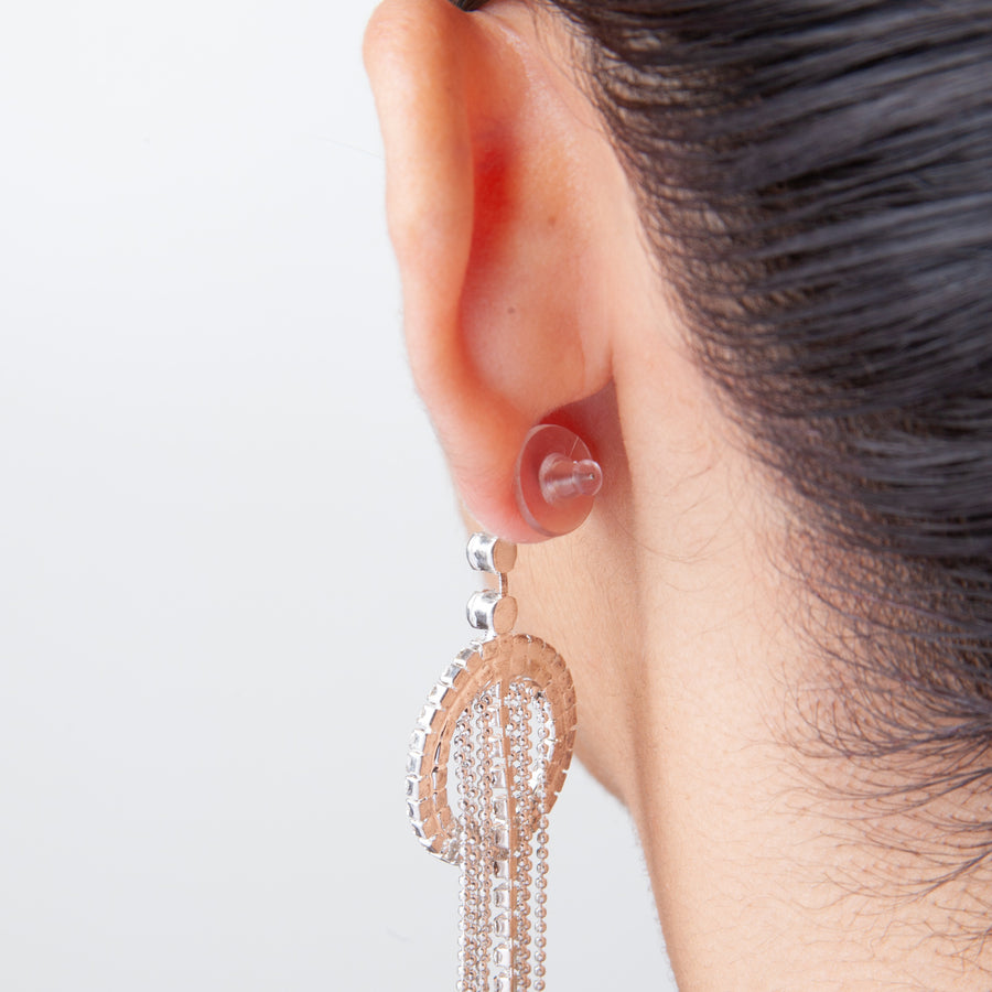 back view of an ear showing how a clear disc earring back fits when attached to a stud earring post.