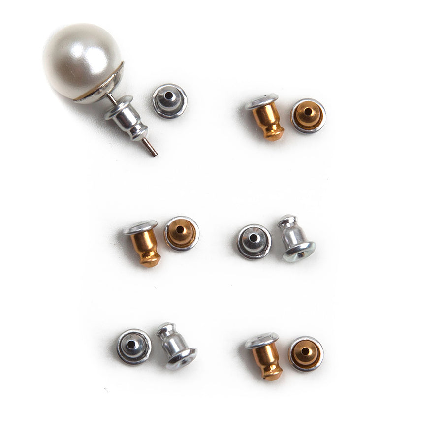 Gold and silver aluminum earring backs laid out in two vertical lines with one pearl earring showing how the earring back fits onto a stud earring.