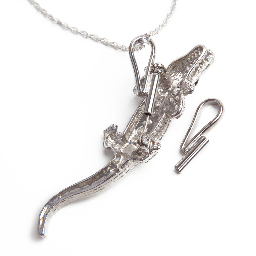 Silver vertical pin to pendant converter laid next to a silver necklace using a silver vertical pin to pendant converter with a silver alligator brooch.