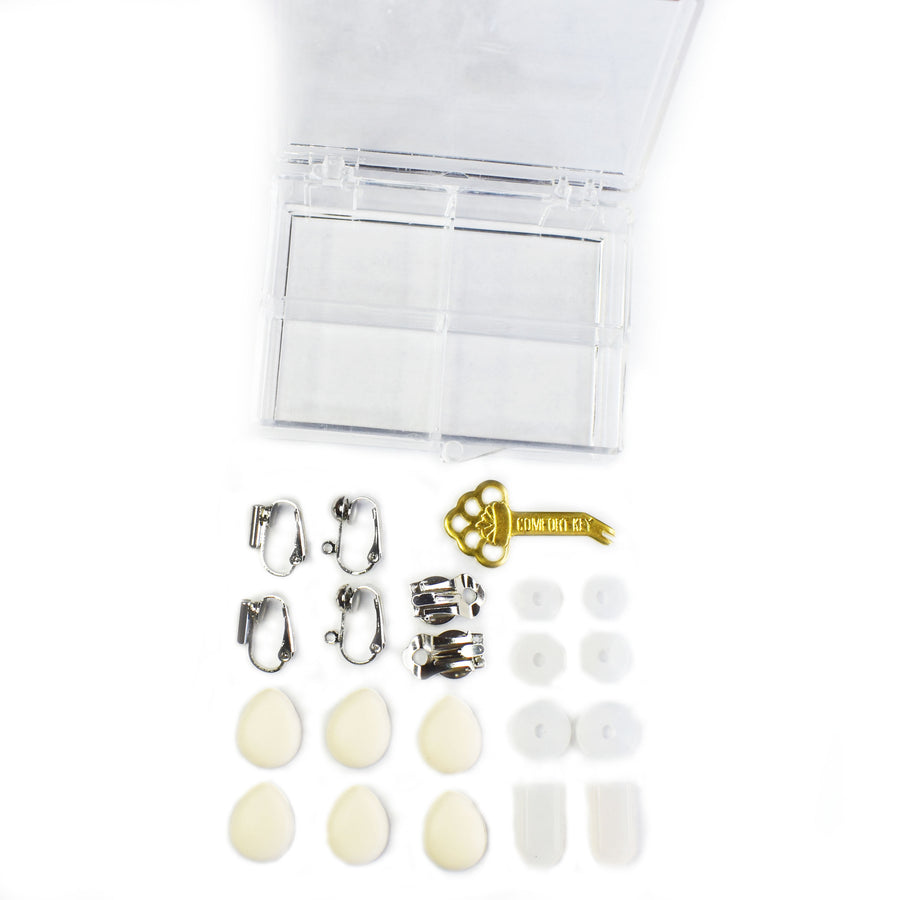 Three type of earring converters, three types of clip earring cushions, and a tension key laid out in from of a clear plastic compartment box against a white background.